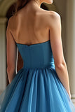 Un vestido de fiesta largo de organza azul escalonado sin tirantes de una línea